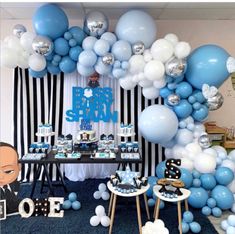 a baby shower party with blue and white balloons, black and white decorations, and an over - the - top cake table