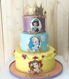 three tiered cake decorated with disney princesses and snowflakes on each layer