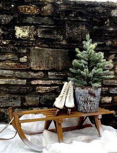 a wooden bench with shoes and a potted plant on it in front of a brick wall