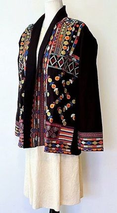 Wearable Art In This Elaborate Hand Embroidered Short Jacket in black. Exquisite craftsmanship handcrafted with intricate embroidery incorporating all the colors in the spectrum.  Each stitch tells a story of tradition and elegance.  100% Cotton, hand embroidered.  Mock collar, engineered front placket border, matching finish on hem and cuffs . This eye-catching piece is perfect for any occasion. It's unique design features intricate details and embroidered patterns that are sure to make a statement. Embroidery is presented in sections. Cuffs have multiple rows of unique stitching. Breast panels also illustrate a totally different stitch. 2 pockets on each side for everyday essentials. True designer quality, back shoulder panel is dramatic and makes a designer statement.  Easy fit jacket i Folk Style Black Outerwear For Festivals, Folk Style Black Outerwear For Fall, Black Folk Style Outerwear For Festivals, Black Folk Style Outerwear For Fall, Black Folk Outerwear For Festivals, Traditional Black Outerwear For Festivals, Folk Style Black Long Sleeve Outerwear, Black Folk Style Long Sleeve Outerwear, Traditional Winter Outerwear With Geometric Embroidery