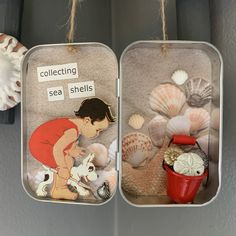 two tin canisters filled with sea shells and seashells hanging from strings