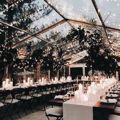 an indoor tent with tables and chairs set up for a formal dinner or wedding reception