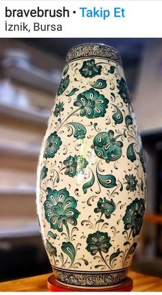 an ornate vase sitting on top of a wooden table