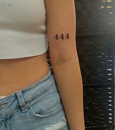 a woman's left arm with the number 414 on it and an arrow tattoo