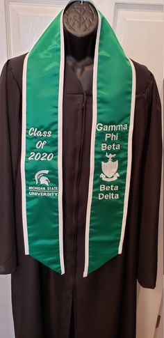 "Custom Embroidered Graduation Stole with Slant Bottom/Trim/Greek or English Letters/Class of 2020/Personalized Stole Polyester Satin Graduation Stole with Slant Bottom and Trim CURRENT PRODUCTION TIME(S) - Text Only 3 Days Text & Graphics* 7 days *Graphics will need to be digitized - please allow additional time for processing. Size 5\" wide X 72\" long (overall) Polyester Satin Embroidery Custom made with your choice of design elements. BASE PRICE: $20.00 = no embroidery Please list what y Grad Stoles, Text Elements, Embroidery Custom, Graduation Sash, Satin Embroidery, Graduation Stole, Text Graphics, English Letters, Class Of 2022