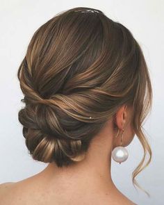 a woman with her hair in a low updo and pearls on the back of her head