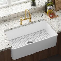 a white kitchen sink sitting on top of a counter