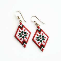 the beaded earrings are red, white and black with green leaves on it's sides