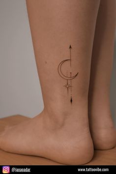 a woman's foot with an arrow and crescent tattoo on the side of her leg