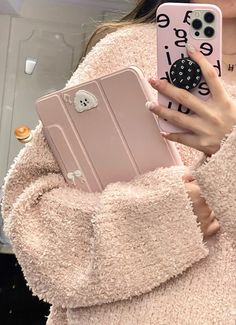 a woman holding a pink phone case in her hand