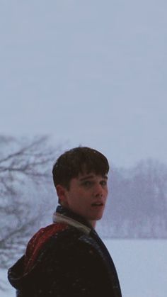 a young man is standing in the snow