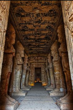 the interior of an ancient building with many statues on it's walls and stairs