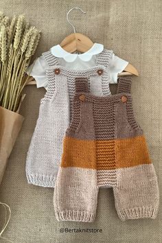 two knitted baby overalls and a plant