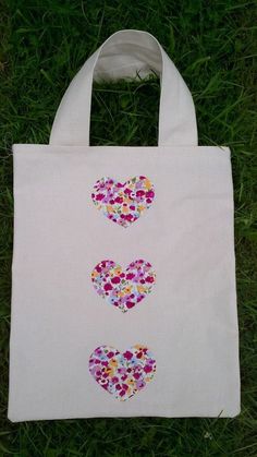 a white bag with hearts on it sitting in the grass