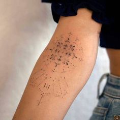 a woman's arm with a tattoo on it that has fireworks in the sky