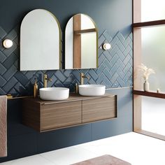 a bathroom with two sinks and mirrors on the wall