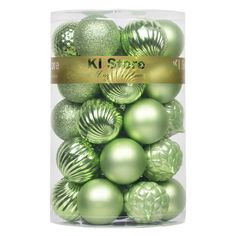 green christmas ornaments in a clear box with gold foil lettering on the top and bottom