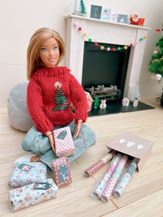 a doll sitting on the floor next to presents