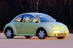 a small green car is parked on the street