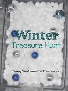 a plastic container filled with white and blue balls next to a sign that says winter treasure hunt