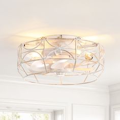 a light fixture in a room with white walls and windows behind the chandelier