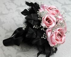 a bridal bouquet with pink roses and black feathers