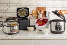 the kitchen counter is cluttered with crockpots, rice and other ingredients