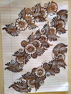 a piece of paper that has some hendi on it with flowers and swirls