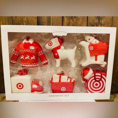 an assortment of christmas ornaments in a box on display with wood background and white frame