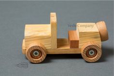 a wooden toy truck with wheels on a gray background and the words vesel company written below it