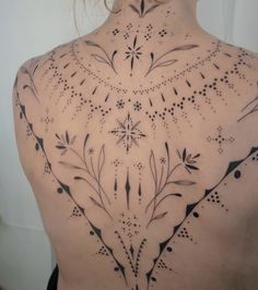 the back of a woman's shoulder with an intricate design on it