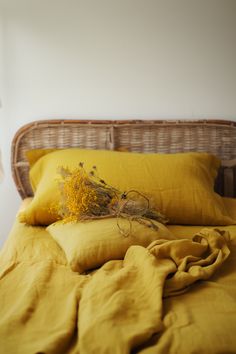 a bed with yellow linens and a wicker headboard