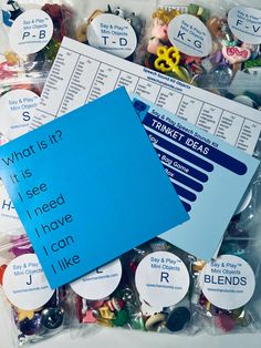 the contents of a plastic bag with buttons and magnets on it, including a blue sheet that says what is it?