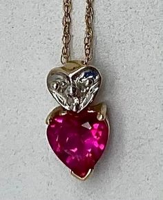 Lovely gold necklace has a small heart shaped Ruby pendant. The necklace chain and pendant are made of 10 karat yellow gold. Above the Ruby heart pendant is a small white gold heart pendant.  Condition: Excellent! Stamped/Marked: 10K & Makers Mark Weight: 1 gram (total with chain) Measurements: 20 inches long (chain) *Pendant: 1/2 inch long  1/4 inch wide *Ruby Heart: 6mm x 6mm 14k Gold Heart Cut Necklace For Valentine's Day, Valentine's Day Heart Cut Necklace Stamped 14k, Valentine's Day 14k Stamped Heart Cut Necklace, Valentine's Day Heart Cut 14k Gold Necklace, Valentine's Day Heart Necklace With 17 Jewels, Valentine's Day Double Heart Hallmarked Necklace, Heart-shaped Hallmarked Necklaces For Valentine's Day, Hallmarked Heart-shaped Necklaces For Valentine's Day, Hallmarked Heart Necklaces For Valentine's Day