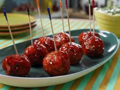 some meatballs with toothpicks in them on a plate