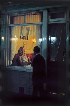 two people standing in front of a window at night