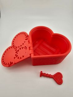 a heart shaped plastic container with a key in it