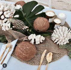 the table is set with candles, flowers and pine cones on burlap cloth