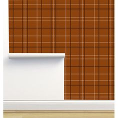 a wall with a brown and white plaid pattern on it, next to a window