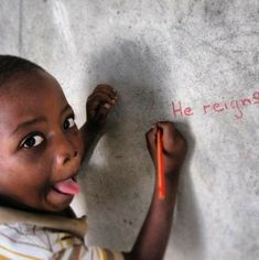 a young boy is writing on the cement