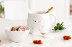 two bowls filled with food sitting on top of a white table next to each other