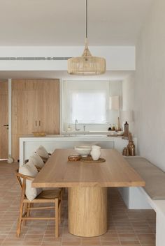 a wooden table sitting in the middle of a kitchen next to a white counter top