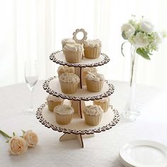 three tiered cupcake display with flowers on the table