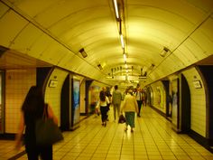 people are walking through an underground subway station