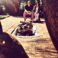 two women sitting on a bench near a fire pit