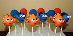 an assortment of orange and blue candy lollipops with clown faces on them