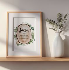 a white vase sitting on top of a wooden shelf next to a framed sign that says mason