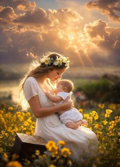 a woman holding a baby in her arms while sitting on a bench with the sun behind her