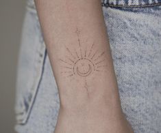 a small sun and moon tattoo on the left inner arm, which is drawn in black ink