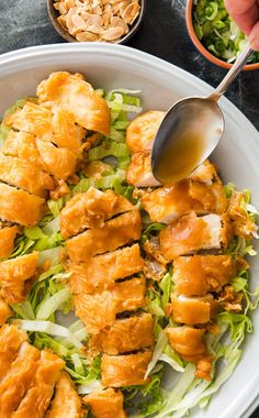 a bowl filled with chicken and lettuce on top of a table